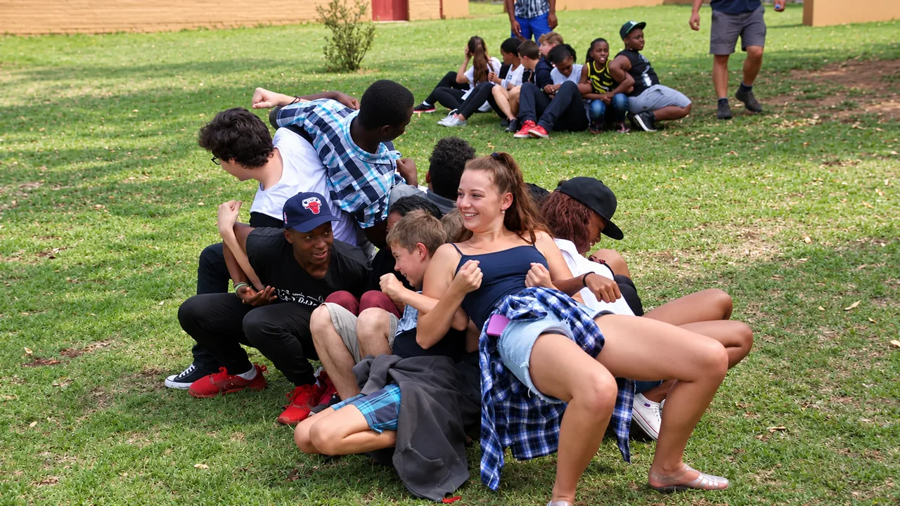 Camp participants helping one another through a team activity