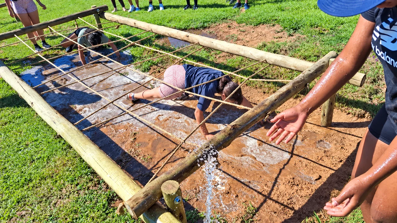 Learners navigating an outdoor mud obstacle