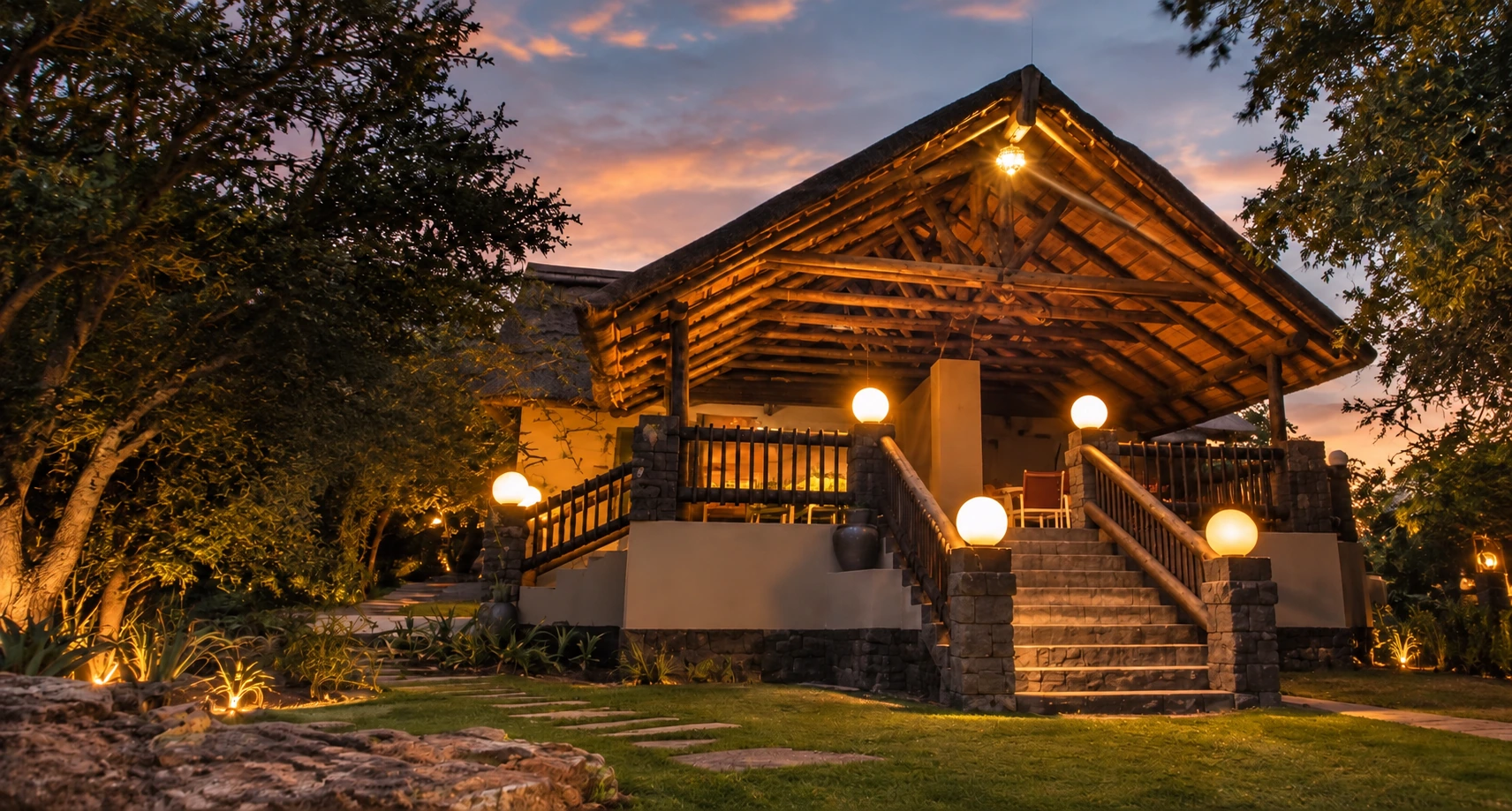 Thatched lodge lit warmly at dusk